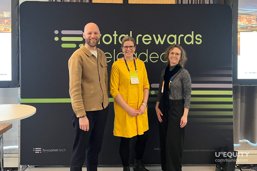 Simone Schmitt-Schillig von Unequity, Ulrich Wendeln von HUGO BOSS und Sandra Strauss von UrbanSportsClub vor dem Poster der Total Rewards Reloaded Konferenz